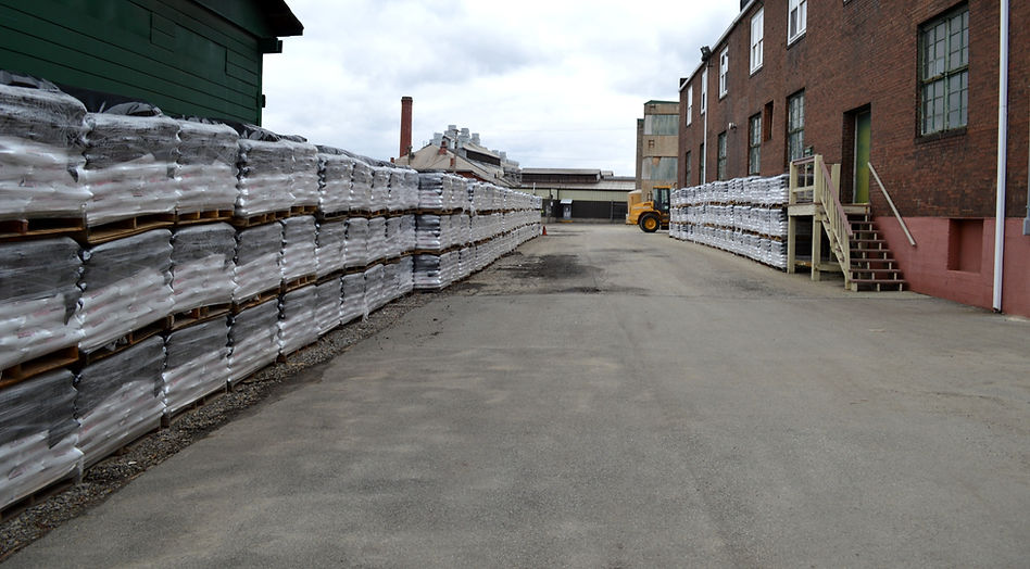 Rows upon rows of bagged rock salt on pallets in stock yard