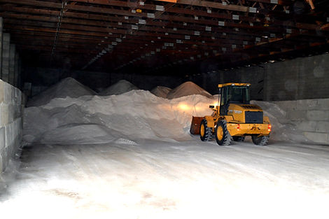 Front loader scopping bulk rock salt from inventory pile