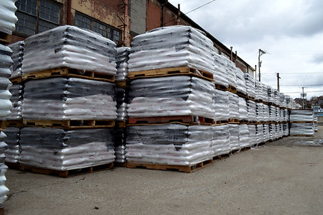 Rows upon rows of bagged rock salt on pallets in stock yard